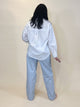 simply julianne white cotton button-down shirt with long sleeves and back pleat detail worn with light blue jeans