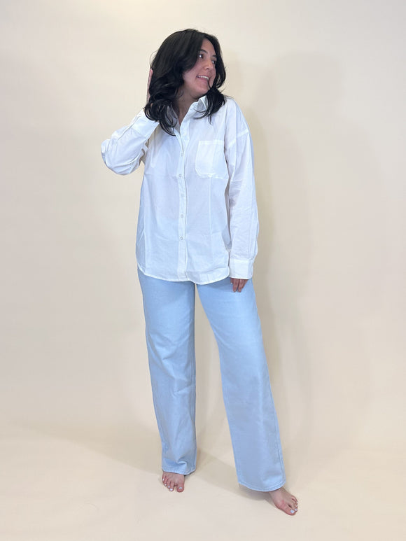 simply julianne white cotton button-down shirt with a front pocket and cuffed long sleeves worn by a woman