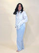 A woman wearing a simply julianne white cotton button-down shirt with a front pocket and light blue denim jeans.